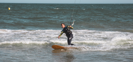 Man in wetsuit kitesurfing in the sea